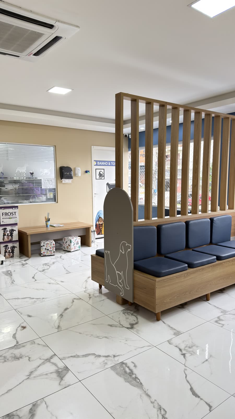 Sala de espera pet friendly da Coellho Pet Center, com bancos e sinalização de banho e tosa